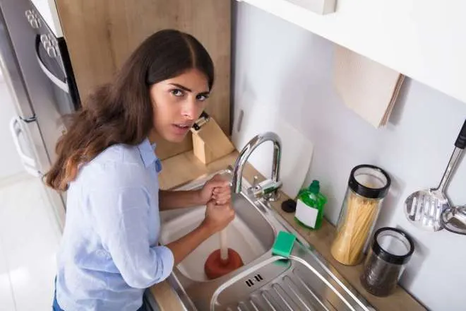 woman plunging sink